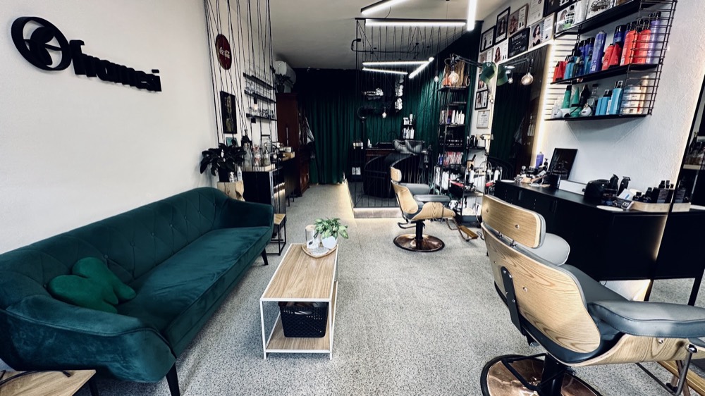 Interiér holičství studio PM cuts & shave — smaragdová sedačka a barberská křesla